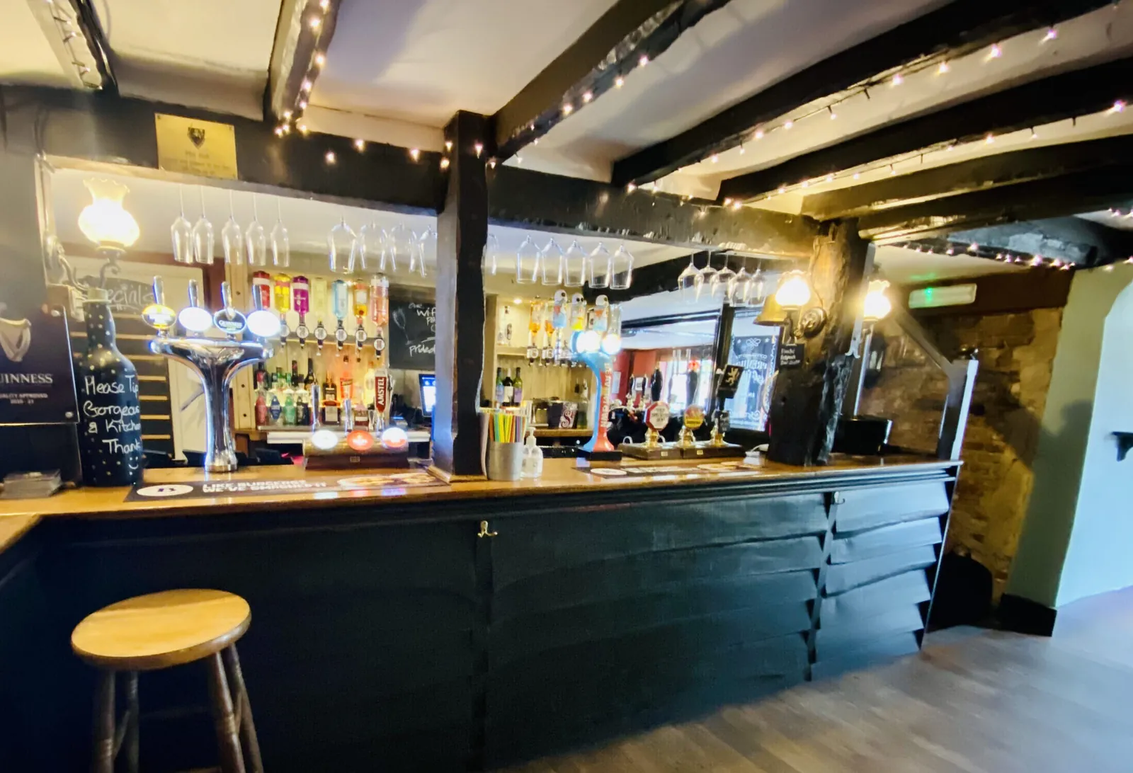 The historic bar of the White Lion with glasses hanging above the counter